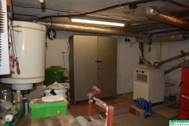 A basement in a family house with a boiler, a wardrobe, and various tools.