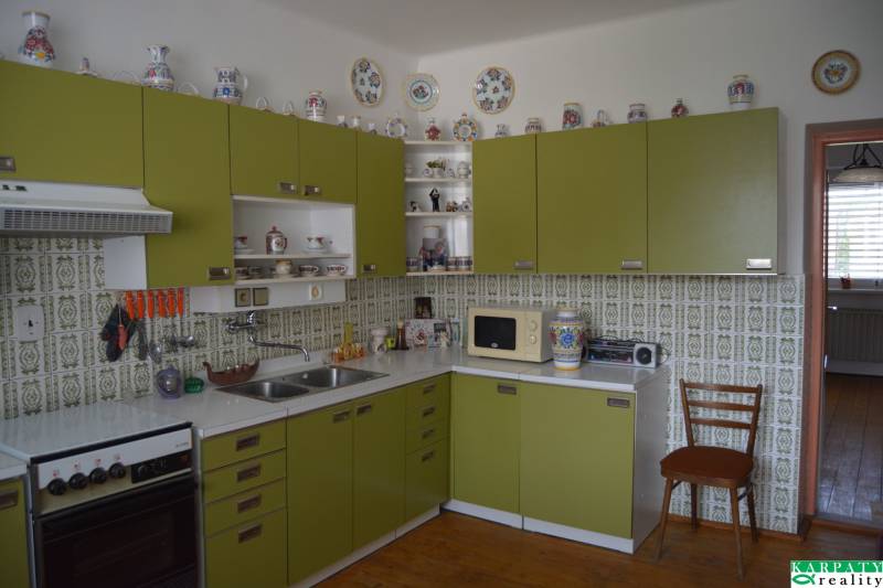 A kitchen in a family house with retro ceramic decorations and green cabinets.