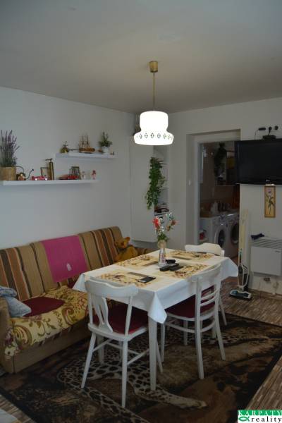 Dining room with a couch, table, TV, and decorations in a family house.