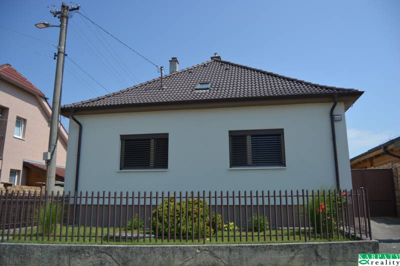 A family house in Trstín with a fence and a garden.