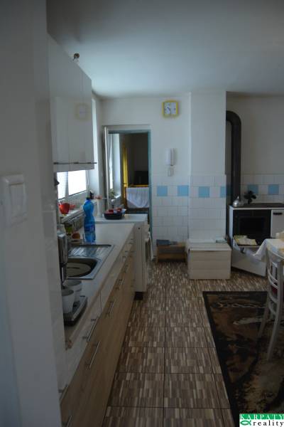 A kitchen in a family house with wooden cabinets, a sink, and a stove.