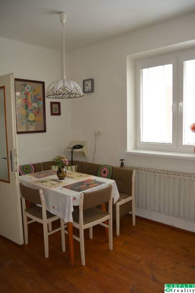 Dining room in a family house with a table, chairs, a painting, and a light fixture.