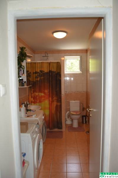 Bathroom in a family house with a washing machine and toilet.