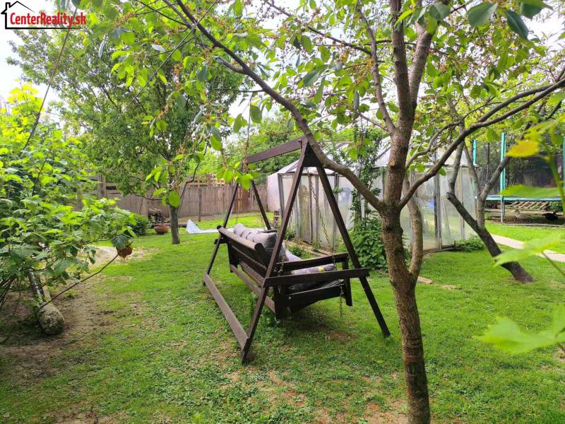 Garden in a family house with a swing, greenhouses, and hidden pathways, Partizánske - Malé Bielice area.