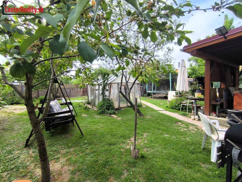 The garden of a family house on a street in Partizánske, Malé Bielice area, with a swing and a greenhouse.