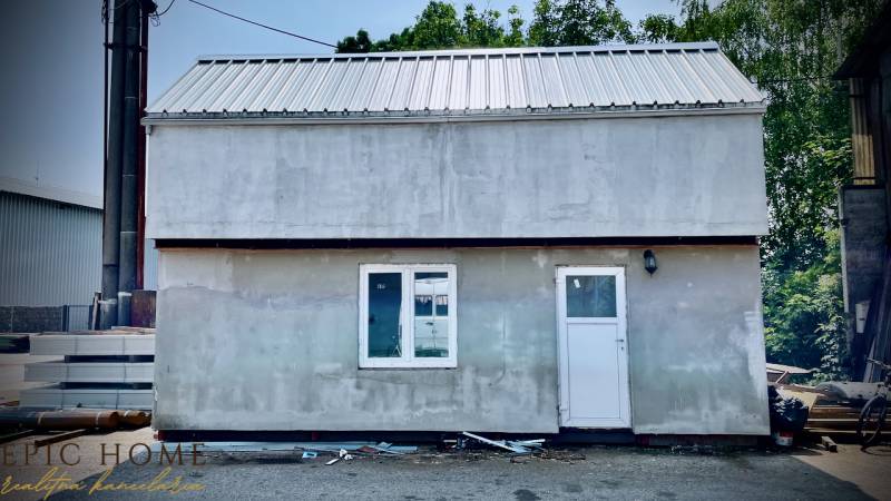 A cottage in Cífer with a metal roof, double window, and white door.