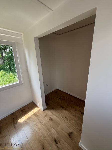 A cozy space with a wooden floor in the interior of a cabin, light passing through the window.