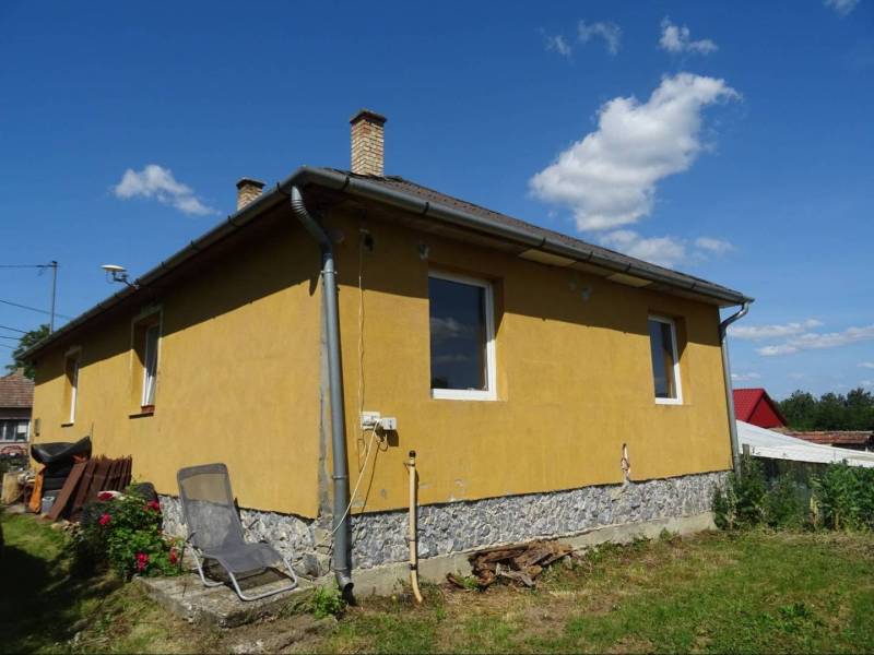 A family house on Futrinka Street in KRASZNOKVAJDA with beautiful flowers and a clear sky.