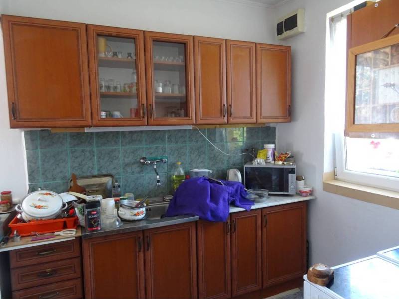 A kitchen in a family house with wooden cabinets and appliances on the countertop.