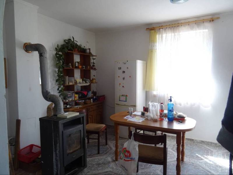 A kitchen in a family house with a stove, table, refrigerator, and furniture for decorations.