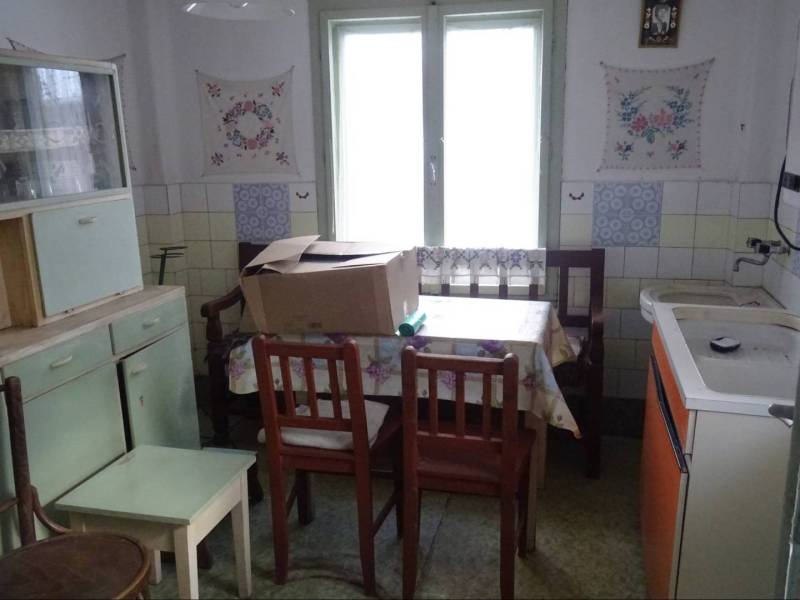 A kitchen in a family house with older furnishings and furniture, floral decorations on the wall.