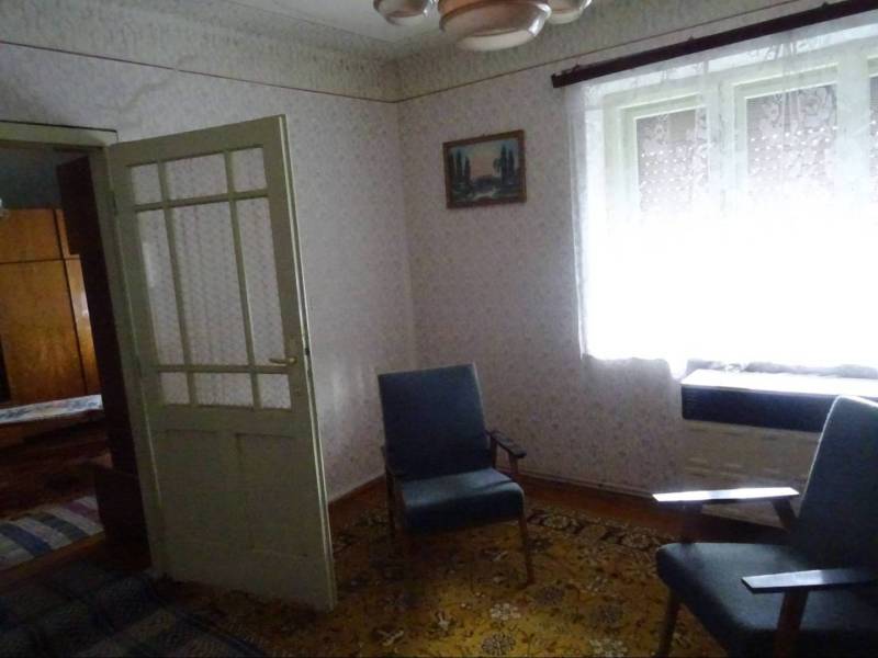 Interior of a family house with retro furniture, carpet, and chairs.