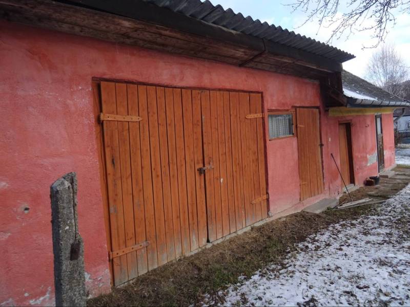 The exterior of a family house in Telkibanya with a wooden gate and a snow cover.