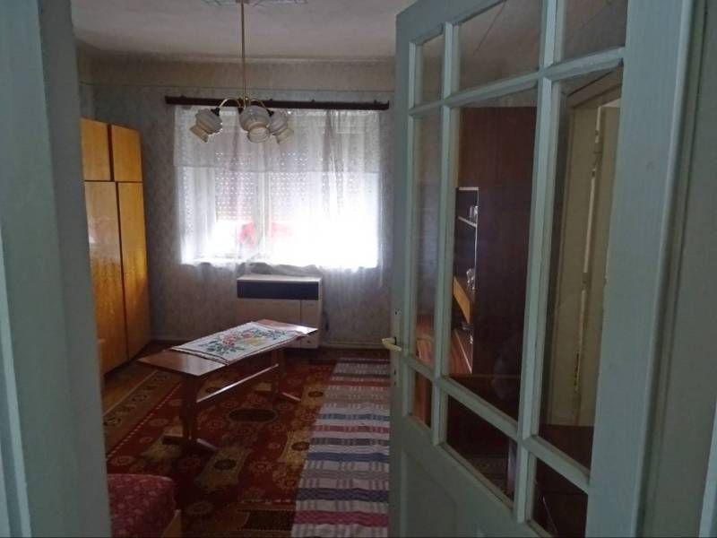 Interior of a family house with wooden furniture, a table, and a decorative carpet.