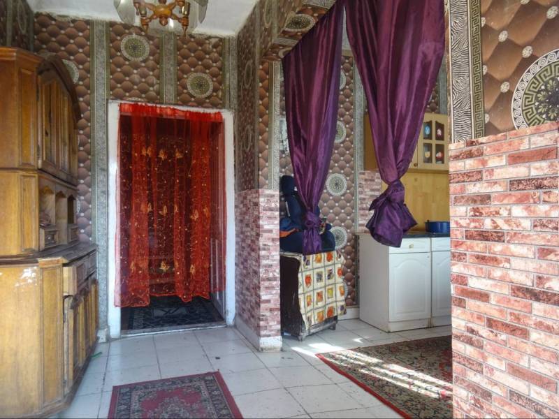 Interior of a family house with curtains, a cabinet, and decorative walls.