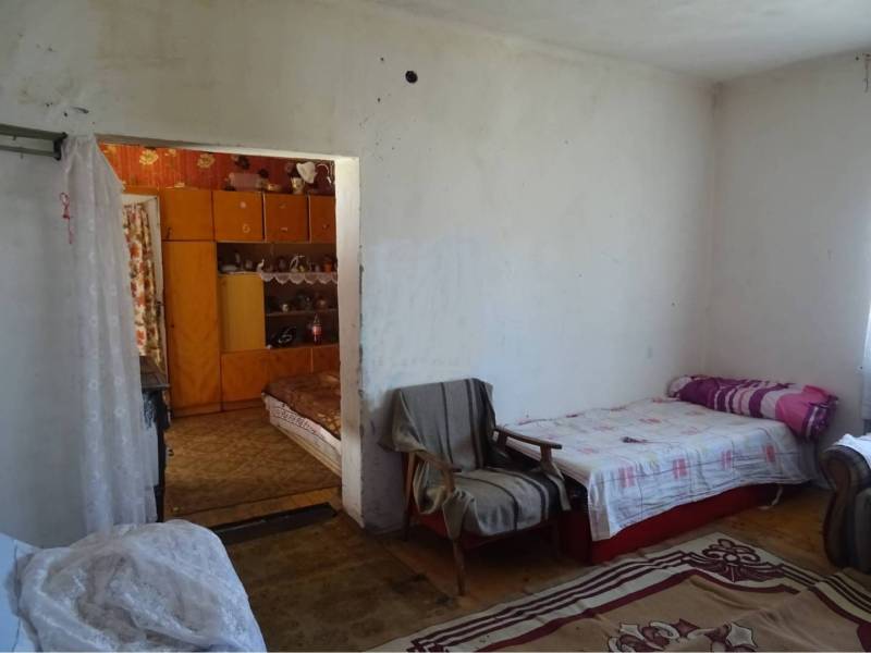 A simple room in a family house with beds and a carpet.