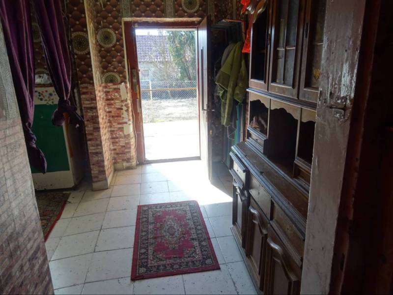A hallway with carpet and wooden furniture in a family house.