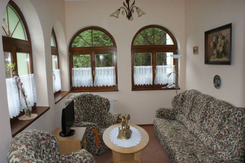 A room in hotels and guesthouses with patterned furniture and arched windows.
