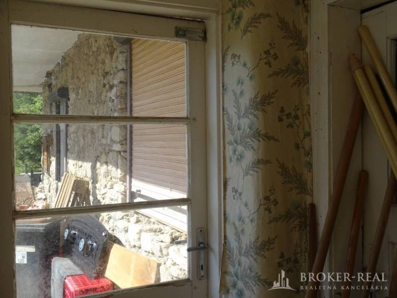 Interior of a family house with wallpapers and a view of stone walls in Pusztafalui.