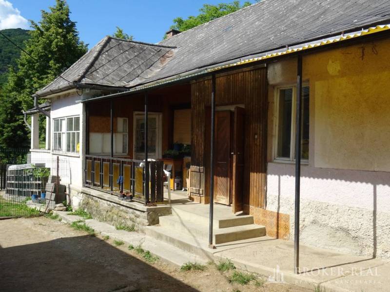 A family house in Pusztafalou with a veranda, garden, and stone foundation.