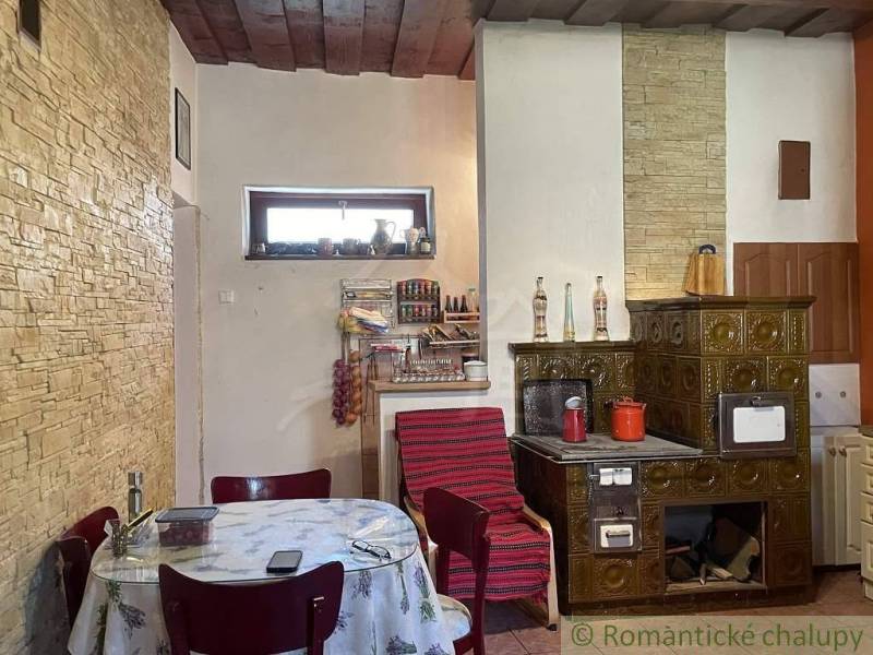 A kitchen with a traditional ceramic stove and a wooden ceiling in a family house.