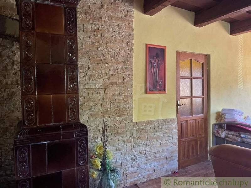 The interior of a family house with a tiled stove and floral decoration in the corner of the room.