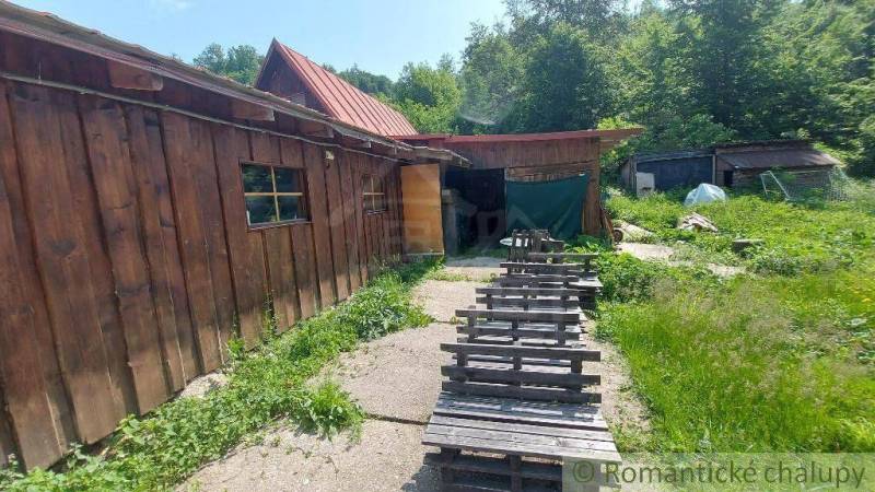 A wooden cabin near Myjava surrounded by greenery and simple seating made from pallets.