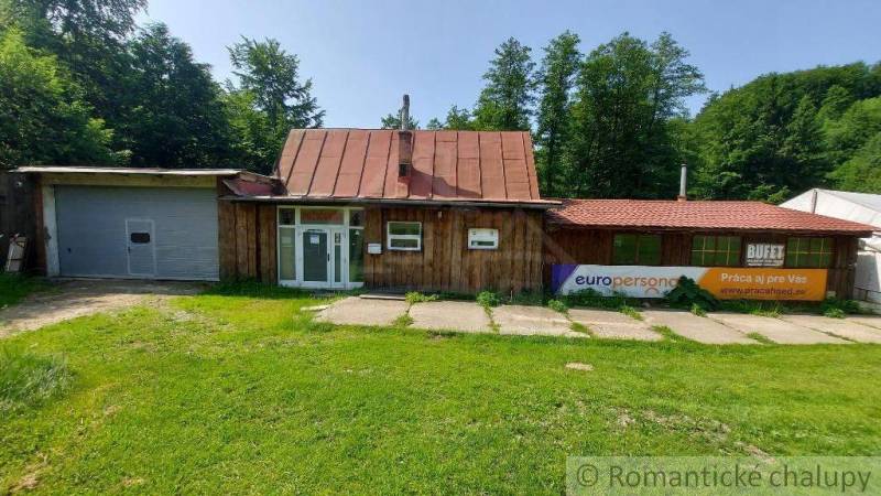 Wooden cottage with a garage surrounded by greenery in Myjava.