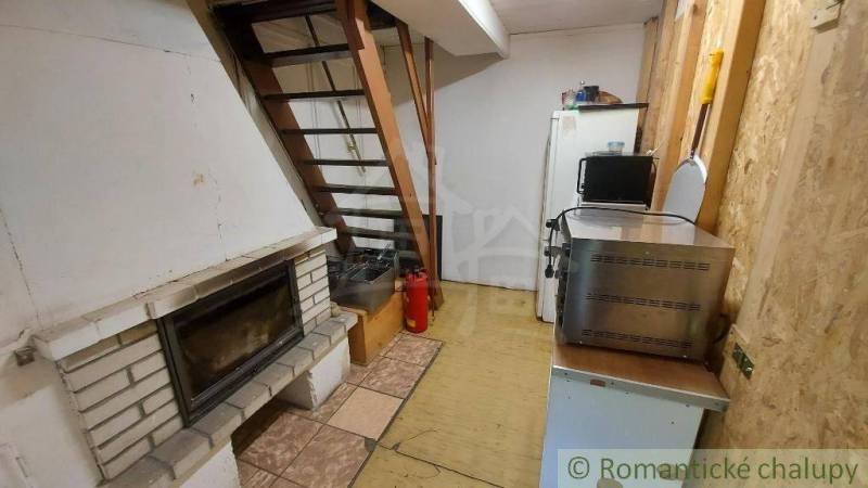 The cottage features a fireplace, a staircase, a kitchenette with a microwave, and a refrigerator.
