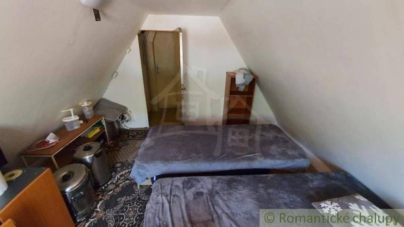 Attic room in a cottage with two beds and storage space.