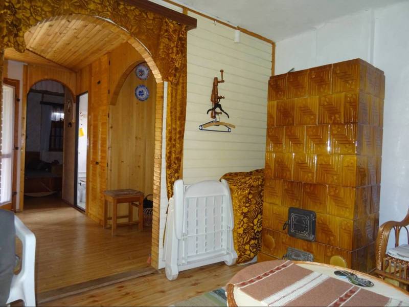 Interior of a family house with wooden paneling, ceramic tiles, and curtains.