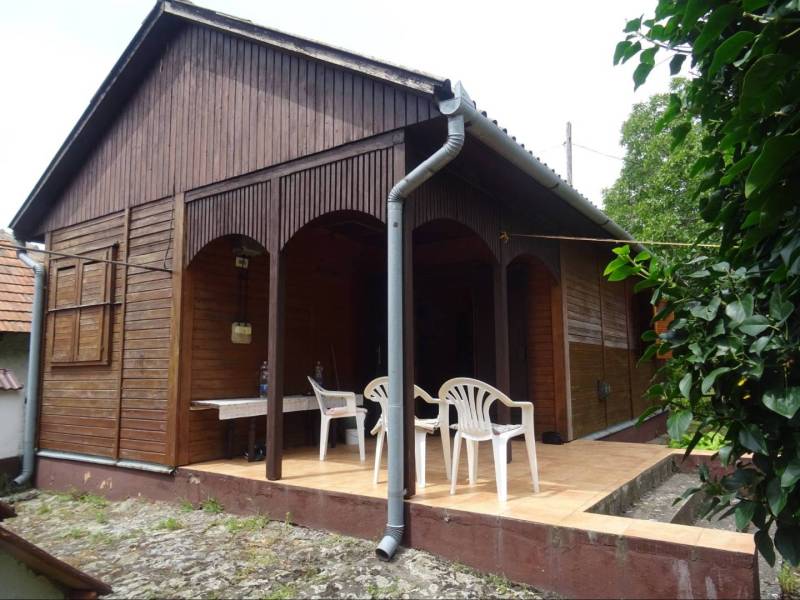 Wooden family house in Fony with a back terrace and plastic chairs.