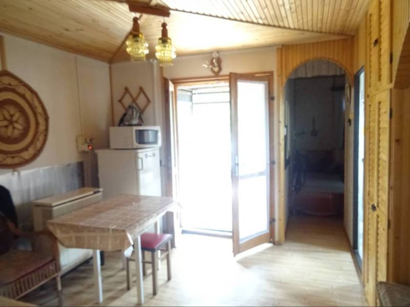 Interior of a family house with a table, chairs, and a refrigerator next to a microwave.