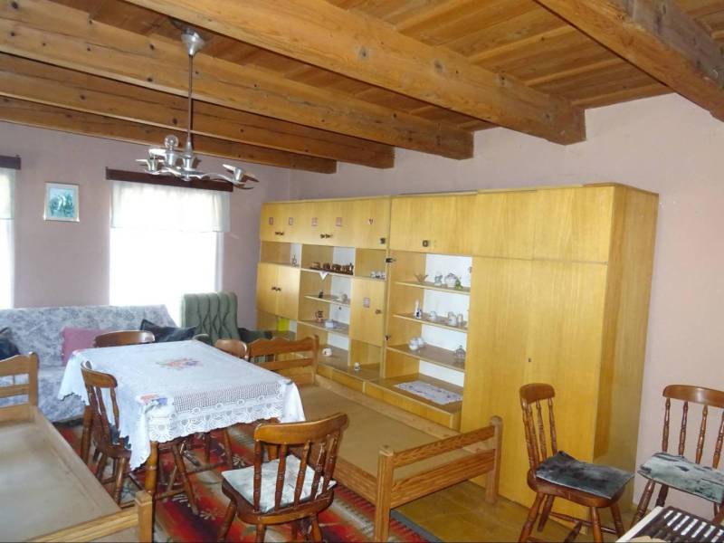 Wooden ceiling, older furniture, and dining table in a family house.
