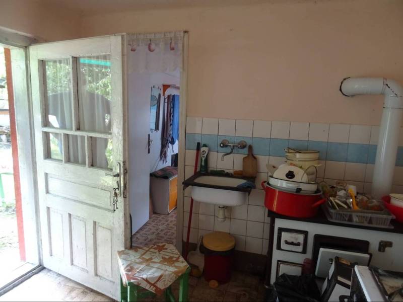 A family house kitchen with rustic equipment and older furniture.