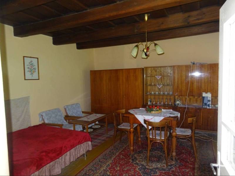 Wooden ceiling, furniture, dining table and chairs in a family house with a carpet.