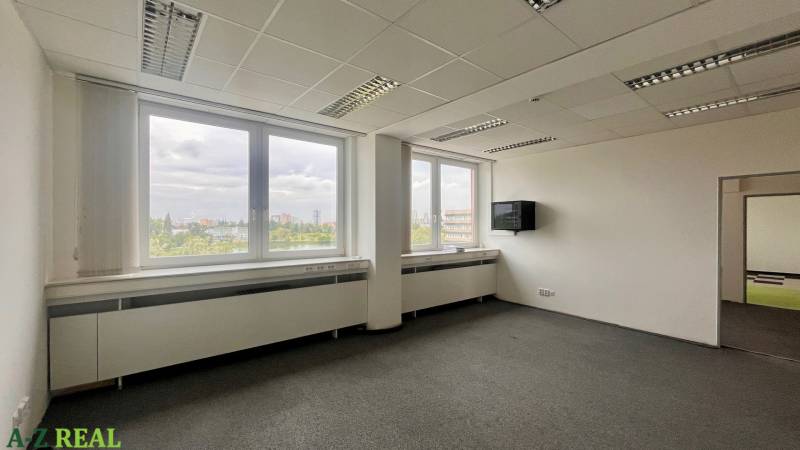 Offices with large windows and a view, simple furnishings, neutral interior.