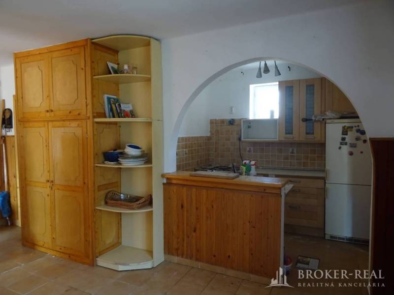 Interior of a family house with a kitchen, wooden furniture, and an arched passage.