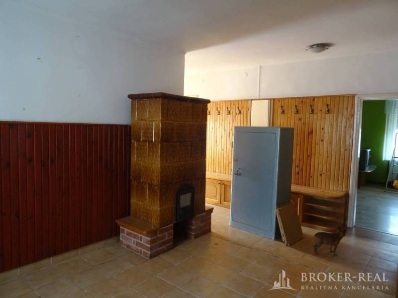 Interior of a family house with a fireplace stove, built-in furniture, and a tiled floor.