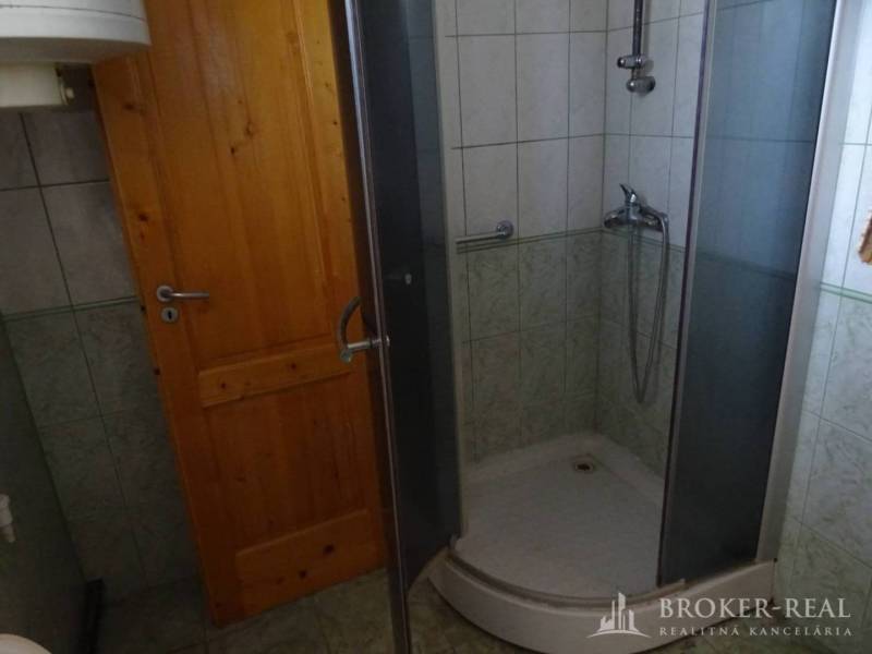 A bathroom in a family house with wooden doors and a shower corner.