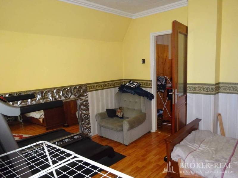 A room in a family house with yellow walls and a treadmill.