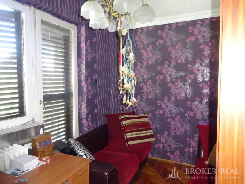 Purple room with patterned walls and furniture in a family house.