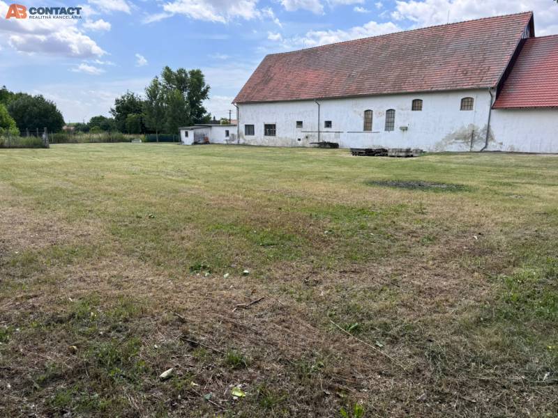 A building with a grassy plot on Zemianske Sady Street in Zemianske Sady near warehouses and halls.