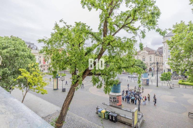 Hviezdoslav Square in Bratislava with a group of people and greenery.
