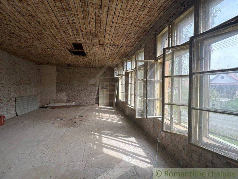 Spacious room with a wooden ceiling and large windows in a family house.
