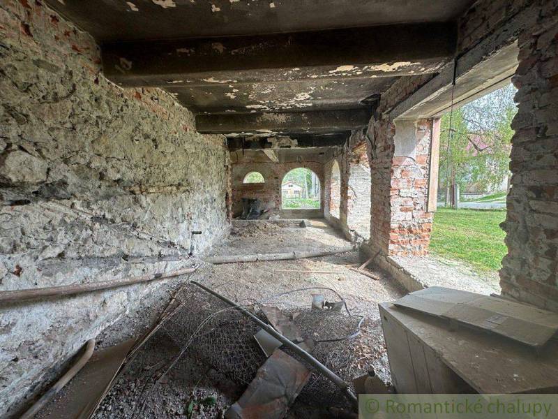 The interior of an unfinished family house with raw walls and a view outside.