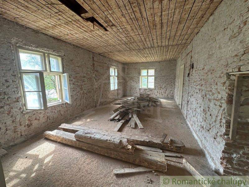An older room in a family house with exposed bricks and wood on the floor.