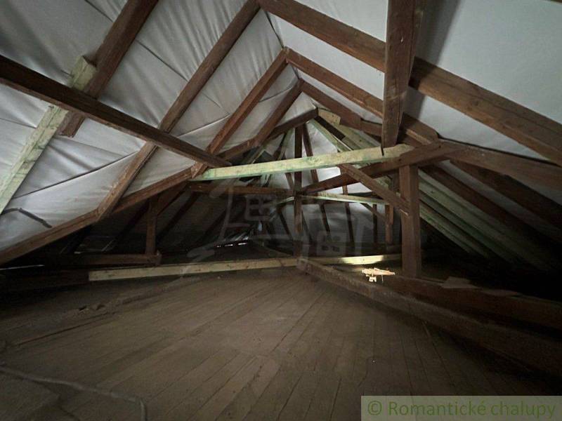 Attic of a family house with wooden beams and floor.