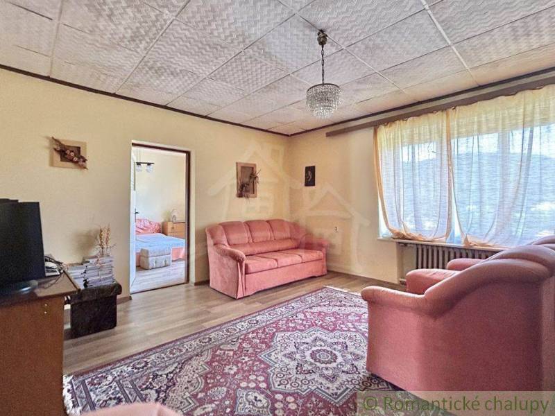 A living room in a family house with a comfortable sofa set and a large window.