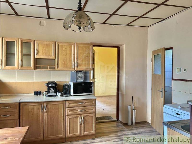 A kitchen in a family house with built-in wooden cabinets and kitchen appliances.